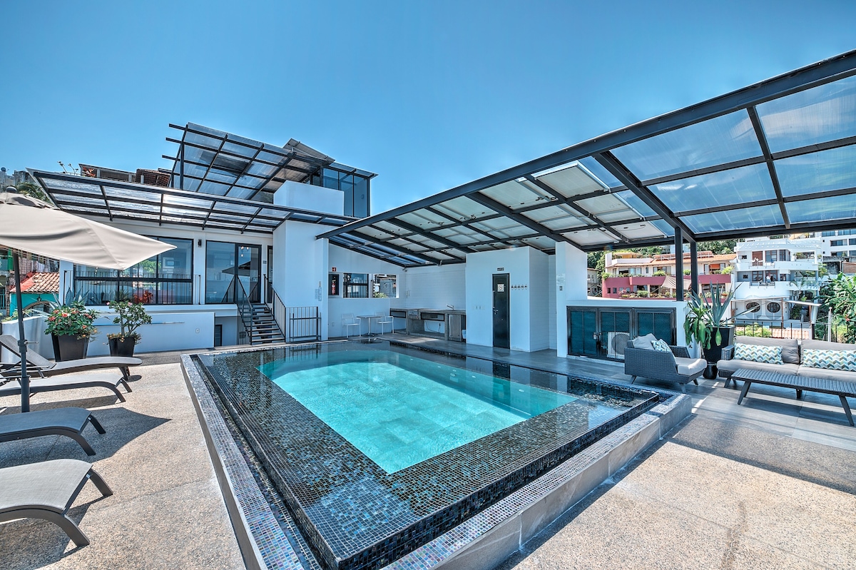 Shared swimming pool with loungers and a covered outdoor area