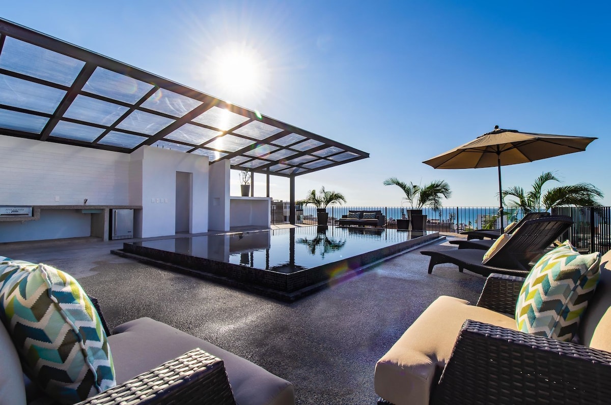 The shared rooftop pool with sun loungers and views towards Banderas Bay