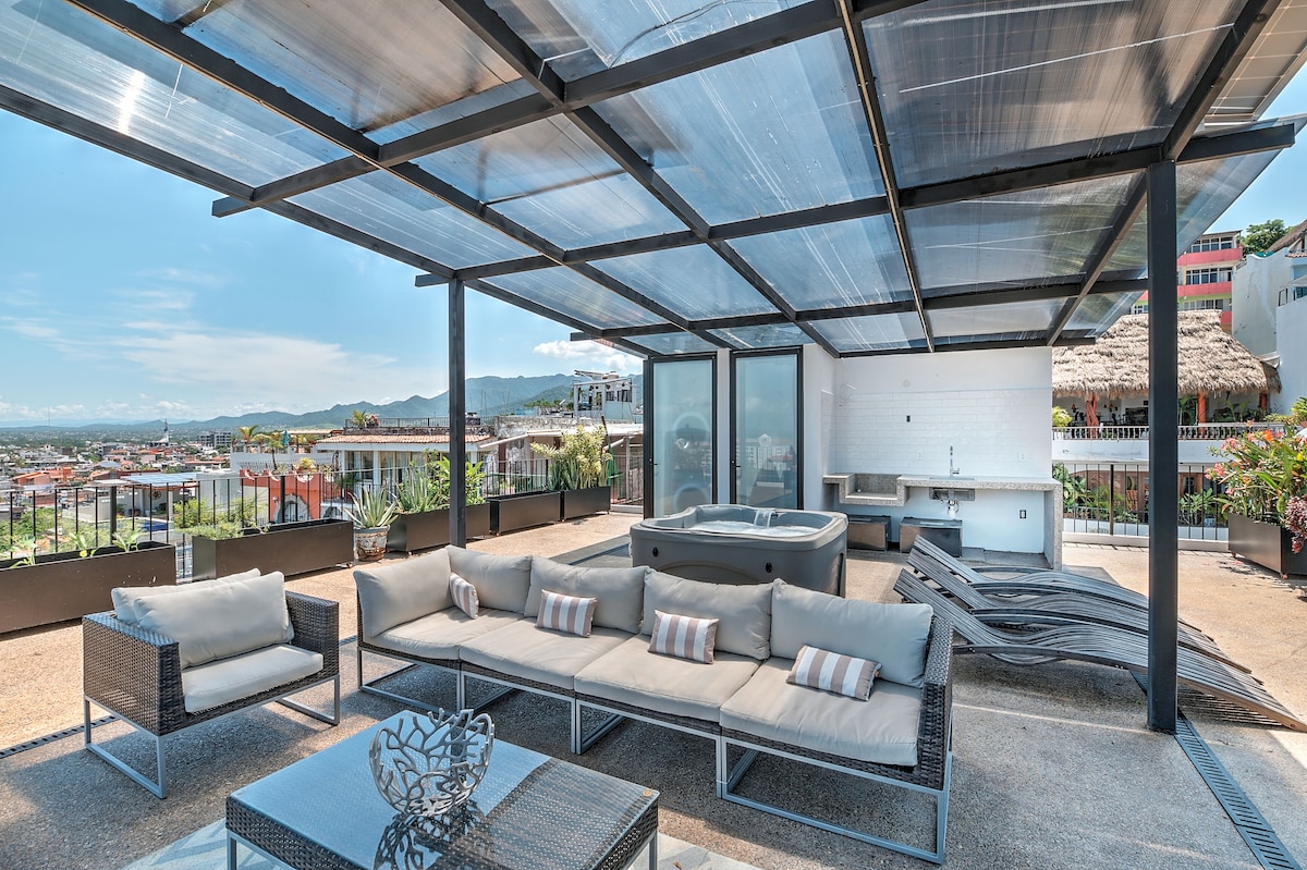 Private terrace seating with the hot tub under a glass canopy